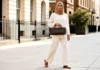 Woman carrying an affordable east west bag uk style on a London street