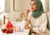 Woman applying fruit flavoured lip balm at a sunlit vanity